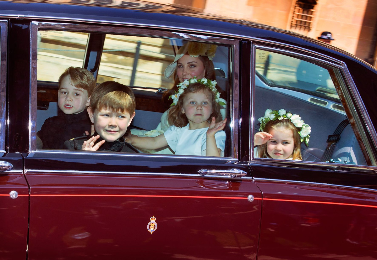 Công nương Kate Middleton cùng hai con là tiểu Hoàng tử George và tiểu Công chúa Charlotte và hai em nhỏ khác ngồi trên ô tô khi tới dự đám cưới của Hoàng tử Harry.