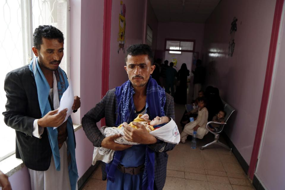 Một ông bố bế đứa con bị suy dinh dưỡng của mình đến bệnh viện ở thủ đô Sanaa kiểm tra sức khỏe.