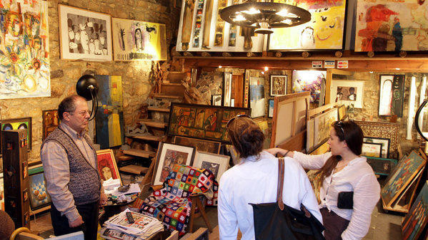 Khách du lịch hỏi mua tranh trong một cửa hàng ở thủ đô Damascus, Syria. Ảnh: Getty.