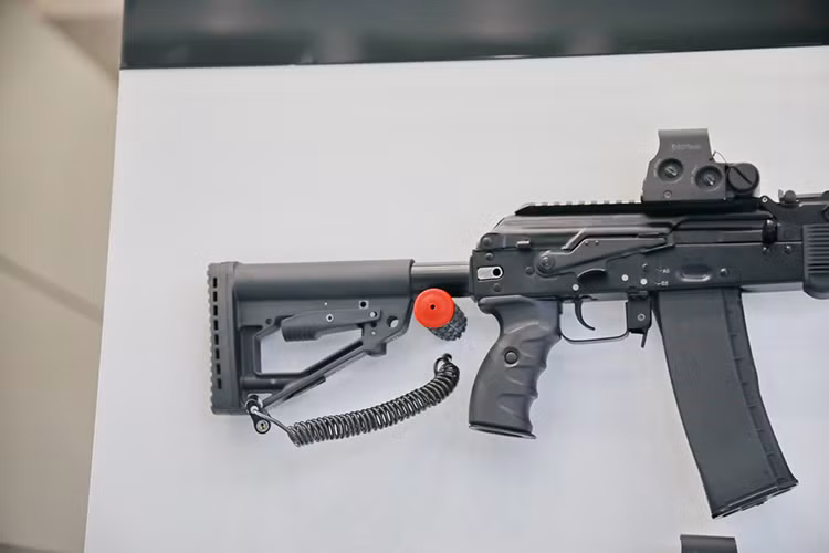 Ở biến thể nâng cấp báng súng của AK-103M cũng được thay đổi từ loại báng nhựa tổng hợp cố định sang loại báng nhựa tổng hợp cho phép tùy chỉnh độ dài của báng và dĩ nhiên vẫn là báng gấp. Ở phần đầu nòng, loa che lửa đầu nòng của AK-103M cũng được thay đổi cùng với đó là loại bỏ thanh thông nòng được đặt bên dưới nòng súng ở các biến thể AK-103 trước đó. Nguồn ảnh: