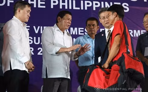 Tổng thống Philippines trao đổi với một ngư dân Việt Nam trong lễ tiễn họ về nước. Ảnh: Phủ Tổng thống Philippines