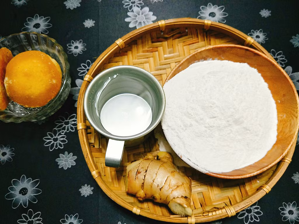 Chuẩn bị nguyên liệu để làm bánh ngào: 150 gram bột nếp, 1 củ gừng, 1 thìa dầu ăn, muối, nước nóng, mật mía hoặc đường thốt nốt.