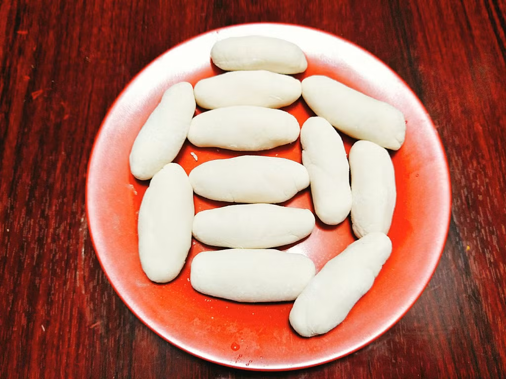 Bột sau khi đã nghỉ xong bạn lấy ra, chia đều thành những viên vừa nhỏ rồi nặn thành hình cái kén, không nên nặn to quá sẽ kém ngon.