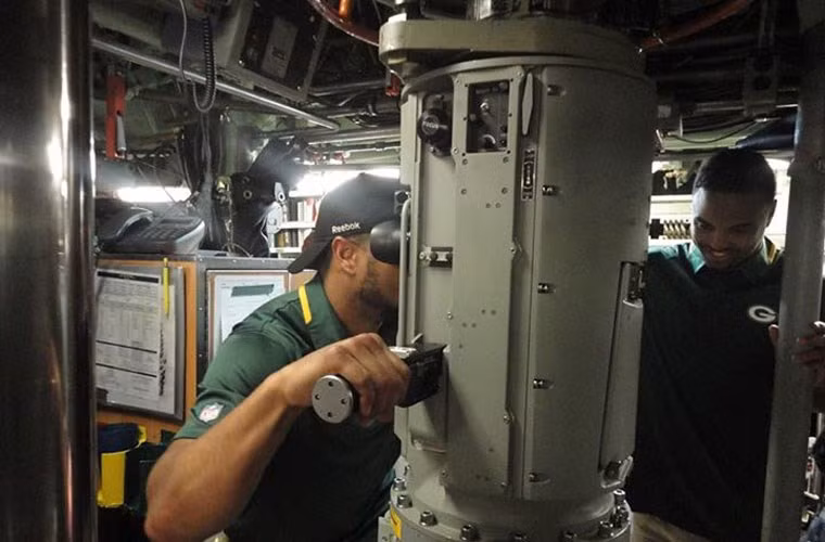 Trong ảnh là một vị khách may mắn thăm tàu USS Chicago đang nhìn qua kính tiềm vọng.