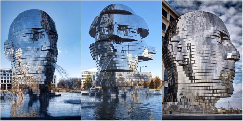 Metalmorphosis là đài phun nước được David Cerny, nhà điêu khắc Czech tạo nên, đặt tại Công viên Công nghệ Whitehall ở Charlotte, North Carolina, Mỹ. Tác phẩm điêu khắc này nặng 14 tấn, được làm từ các lớp thép không rỉ lớn xoay 360 độ. Ảnh: Rick_28105.