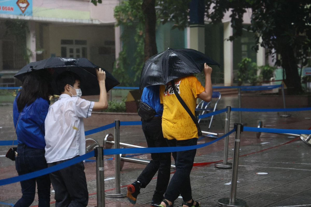 Các thí sinh đều được các tình nguyện viên che ô đó đưa vào khu vực thi bên trong của trường.
