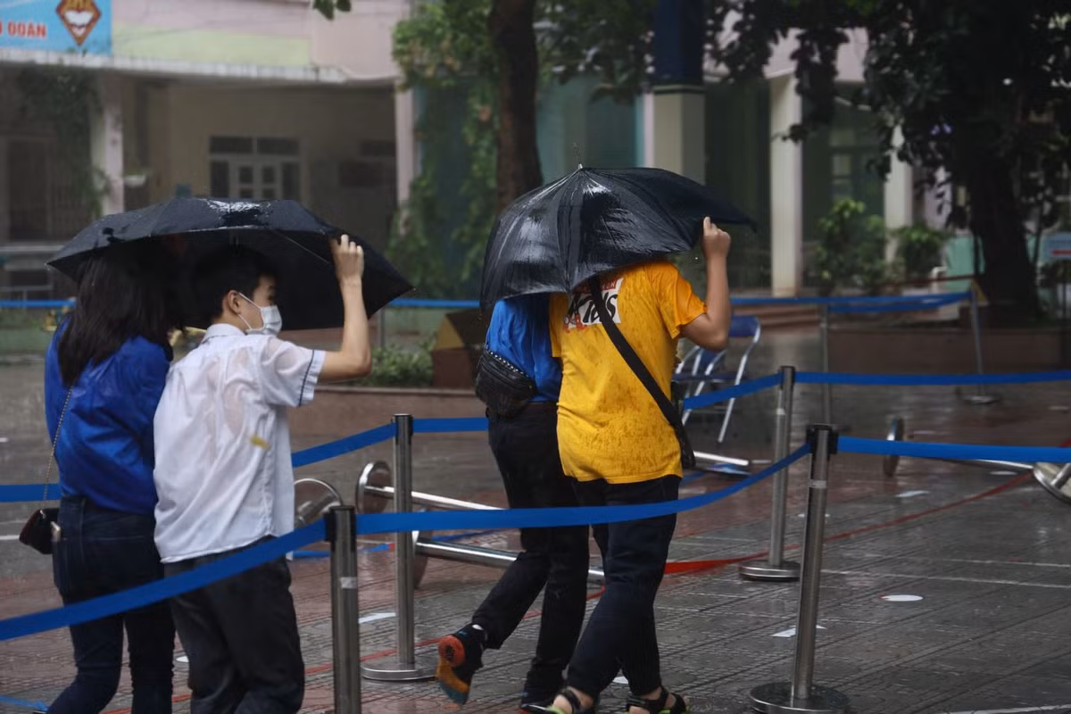 Các thí sinh đều được các tình nguyện viên che ô đó đưa vào khu vực thi bên trong của trường.