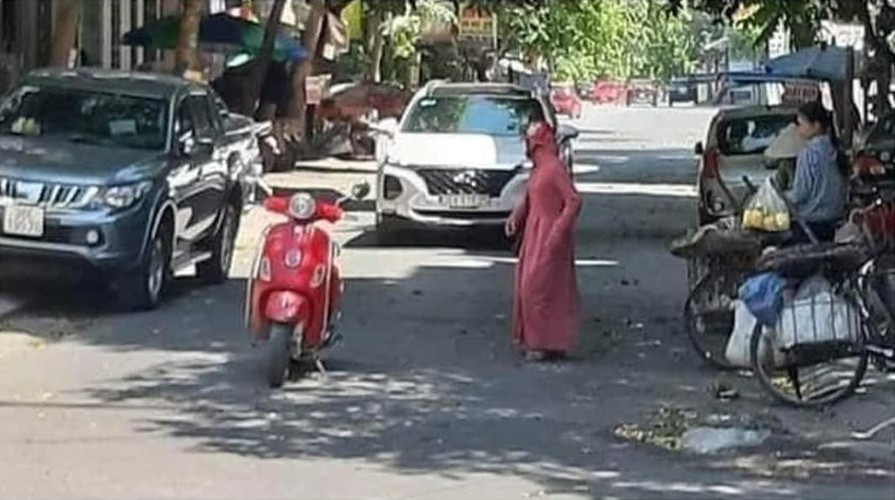 Người phụ nữ "ninja" vì tranh thủ tạt vào chợ cóc mua chút đồ mà ngang nhiên để dừng xe giữa đường gây cản trở cho chiếc ô tô phía sau.