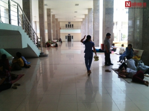 Sảnh chính đường đi ra khoa Hồi sức cấp cứu của Bệnh viện K3 cũng có không ít người nhà bệnh nhân ngồi nghỉ ngơi. Đa số đều chọn chân cầu thang vừa khuất, vừa mát mẻ.