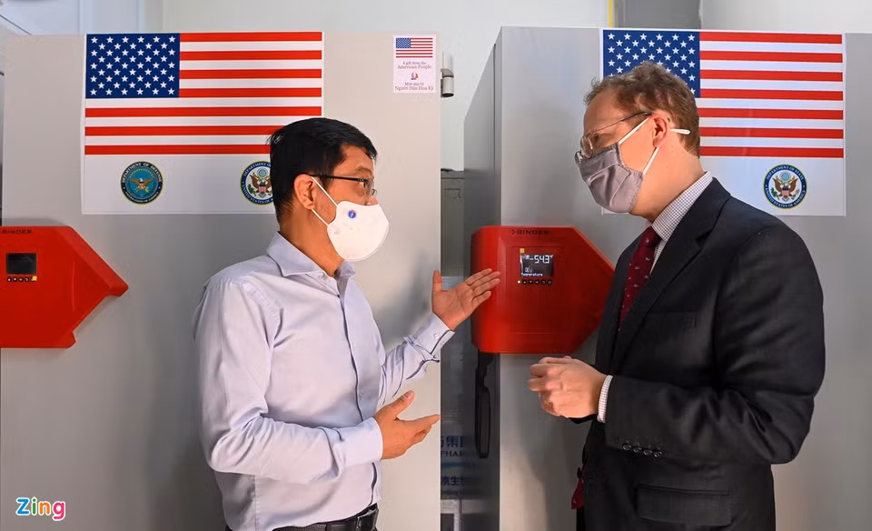 Cũng trong lễ tiếp nhận, Đại biện lâm thời Mỹ tại Việt Nam Christopher Klein (phải) thông báo Mỹ sẽ chuyển thêm 400.000 liều vaccine nữa cho Việt Nam trong những ngày sắp tới. Trong ảnh, ông Klein đang trao đổi với Viện trưởng NIHE Đặng Đức Anh.