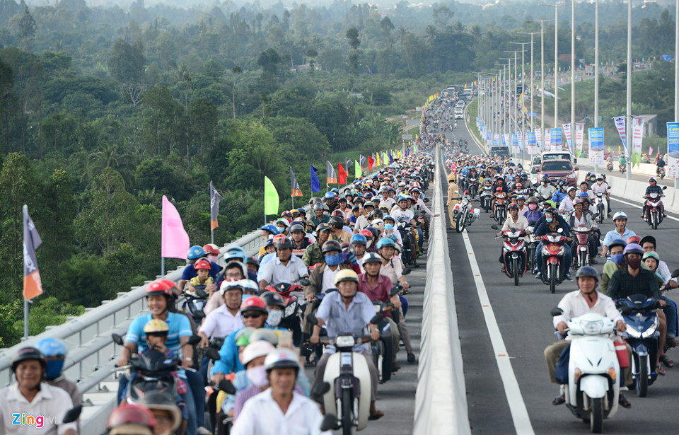 Tại dốc lên hai bên cầu, làn đường dành cho xe máy kín đặc. Lực lượng chức năng mở thêm làn phần ôtô để giải phóng tình trạng ùn tắc cục bộ.
