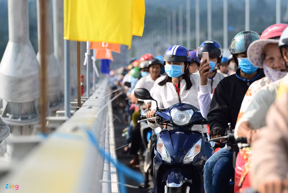 Dù xe cộ đông đúc, di chuyển chậm nhưng nhiều người vẫn cố gắng nhìn ngắm, chụp hình cây cầu dây văng, cảnh quan sông Tiền.