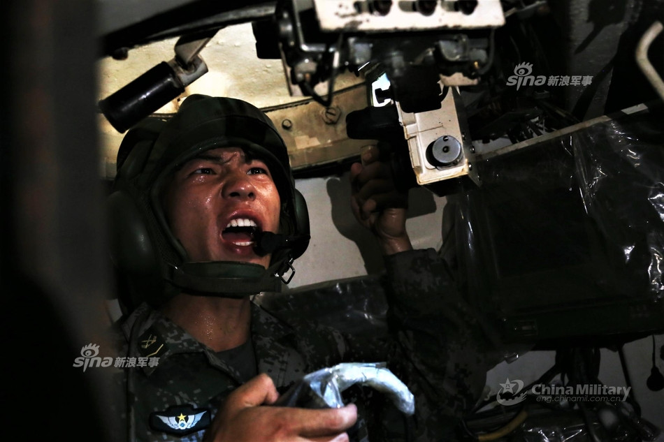 Xe bao gồm kíp chiến đấu 4 người, trong đó có một trưởng xe, một lái xe, một xạ thủ và một nạp đạn viên. Ảnh: Trưởng xe của một chiếc Type 63 nhễ nhại mồ hôi chỉ huy tác chiến. Nguồn ảnh: Sina.