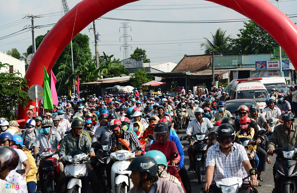 Đến 15h20, lực lượng chức năng mở rào chắn lối vào từ giao với quốc lộ 30, hàng nghìn người chạy xe máy, ôtô ào ào chạy vào đường dẫn lên cầu.