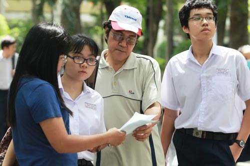 Phụ huynh cùng thí sinh xem lại đề thi trong kỳ thi tuyển sinh vào lớp 10 năm 2017 Ảnh: HOÀNG TRIỀU