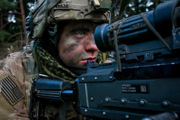 Một quân nhân Mỹ đang quét địa hình qua kính ngắm của khẩu súng máy M-249, trong một cuộc huấn luyện ở Đức.