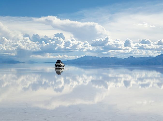 15. Cánh đồng muối Uyuni ở tây nam Bolivia: Với hồ muối trắng muốt in bóng bầu trời đầy mây tạo ảo giác đi bộ trong mây.