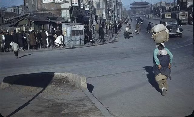 Một bà mẹ đang địu con, đội hàng mưu sinh trên phố.