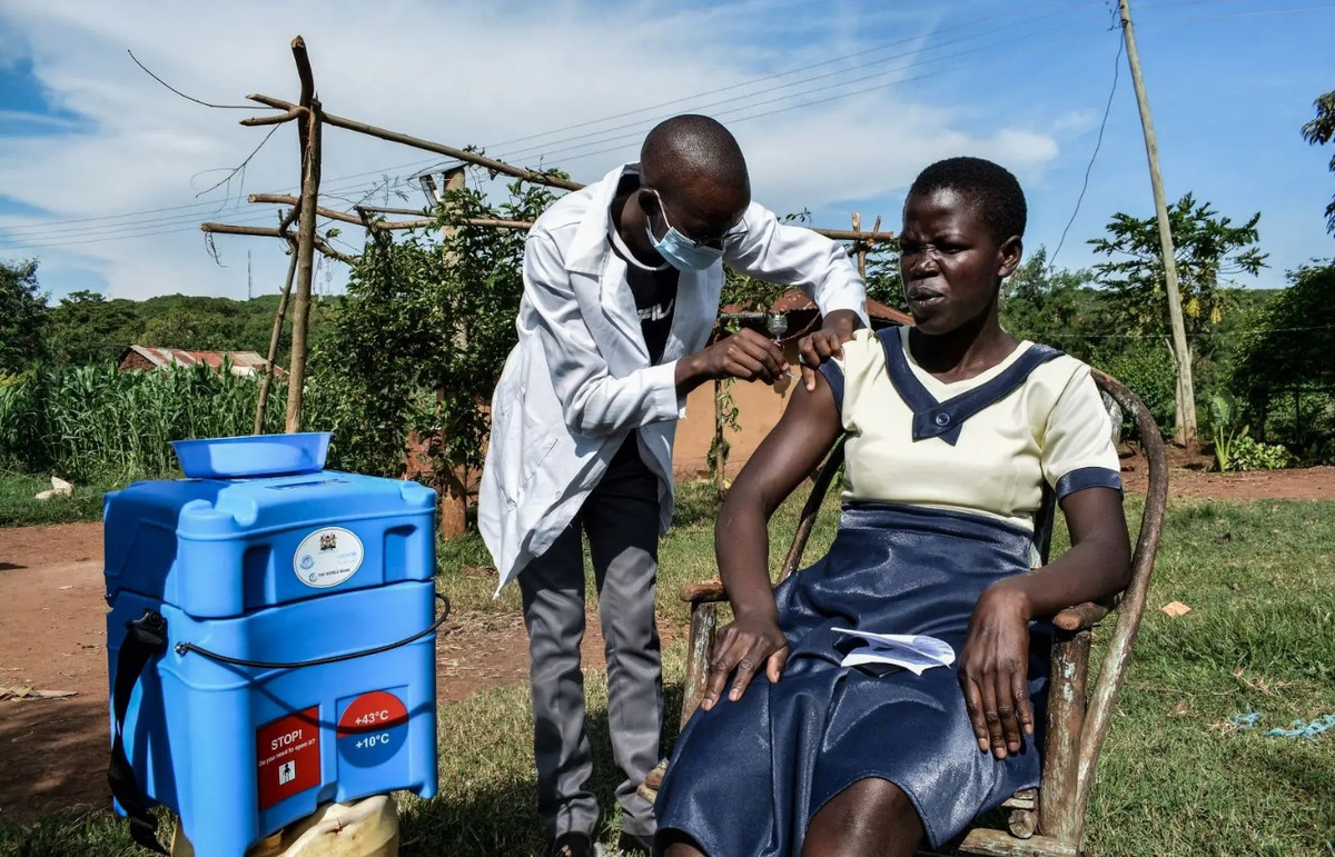 Một nhân viên y tế gõ cửa từng nhà để tiêm chủng vaccine ngừa Covid-19 cho người dân tại Siaya, Kenya vào tháng 5. Ảnh: AFP.