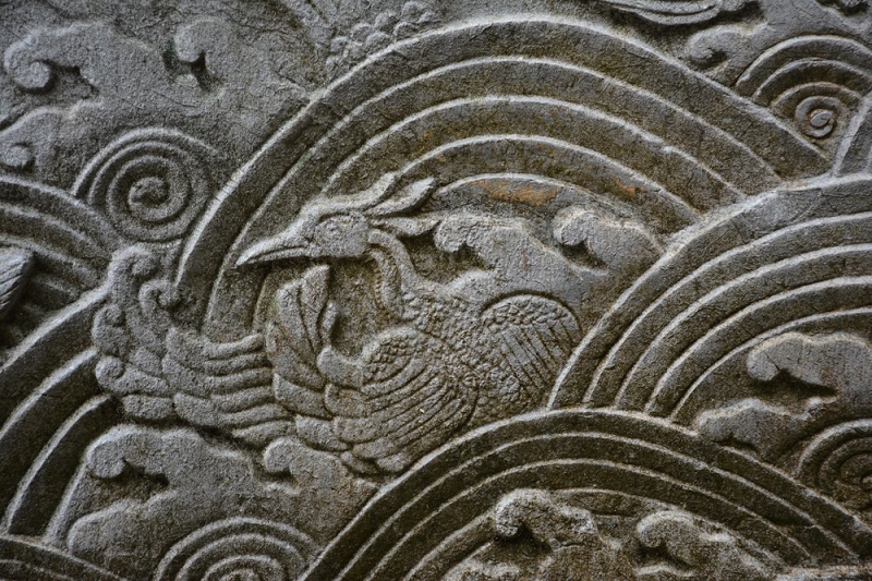 Mặt ngoài lan can hình tam giác có đường diềm chạm một nửa hình hoa liên tiền nối tiếp nhau, góc tạo bởi 2 đầu cánh hoa chạm một nửa hình hoa cúc. Bên trong khung hình tam giác vuông, chạm đề tài cá hóa rồng trong đầm sen. (Ảnh: Tiền phong)