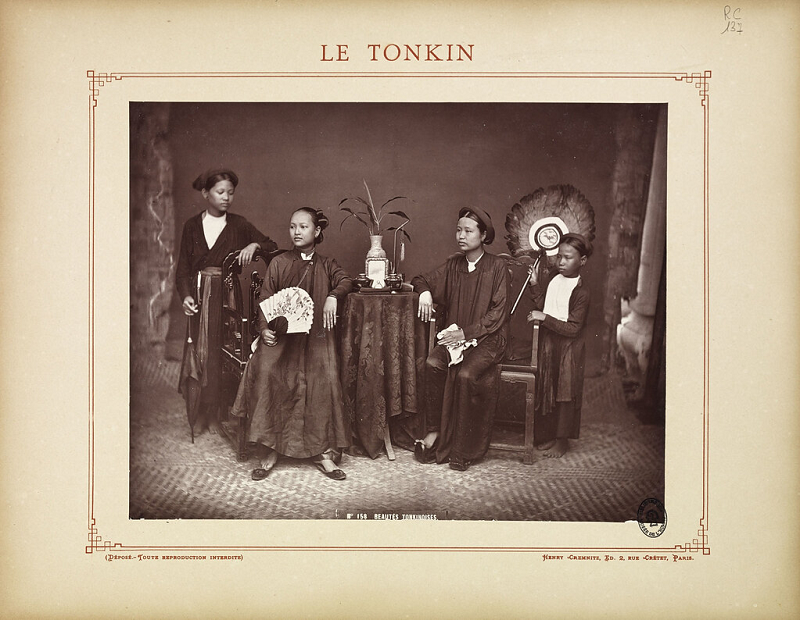 Hai phụ nữ thuộc giới quyền quý ngồi ghế và hai gia nhân đứng hai bên.