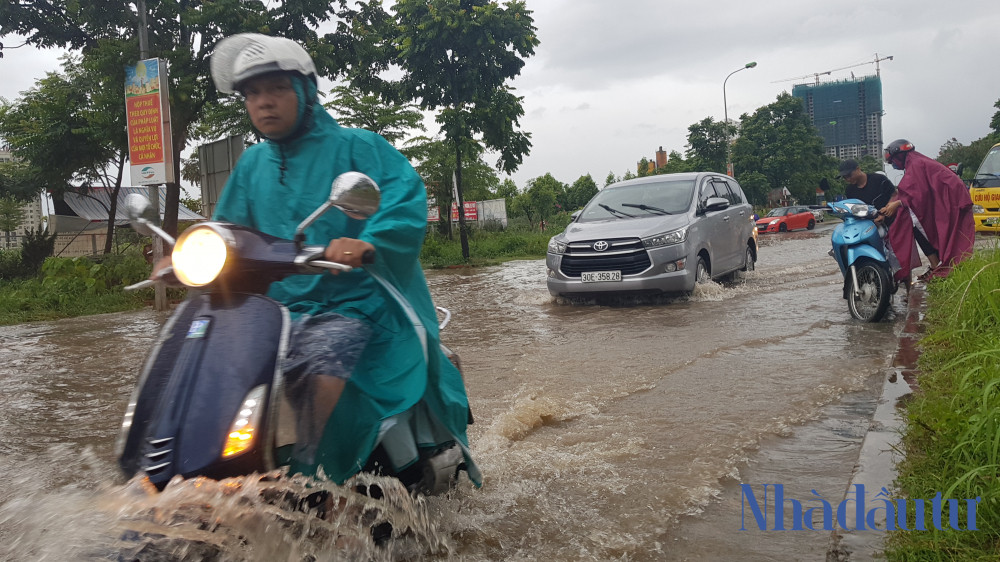 Nhiều người vẫn liều mình đi xe qua đoạn đường ngập sâu ở đường ven Đại lộ Thăng Long.