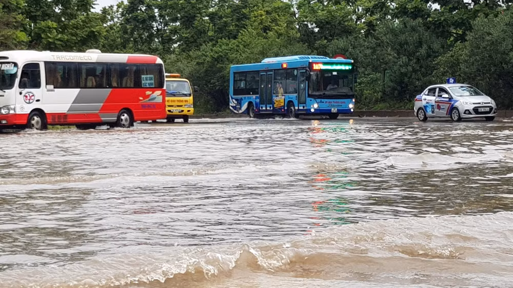 Xe buýt đi lại cũng gặp khó khăn khi đi qua đoạn đường ngập.