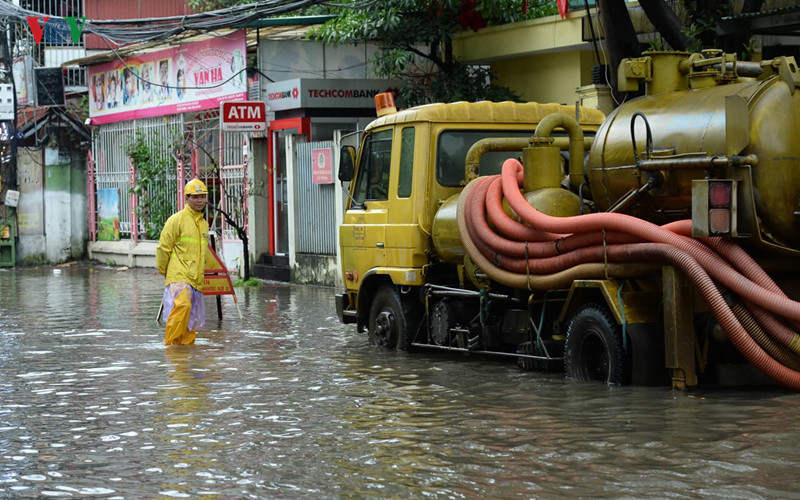 Dù đã nỗ lực, song công nhân Xí nghiệp thoát nước số 2 và xe bơm thoát nước cũng không thể khiến mực nước giảm bớt vì các cống thoát đều đã đầy.