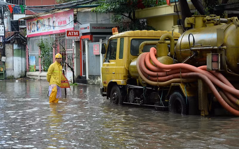 Dù đã nỗ lực, song công nhân Xí nghiệp thoát nước số 2 và xe bơm thoát nước cũng không thể khiến mực nước giảm bớt vì các cống thoát đều đã đầy.