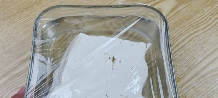 Phương pháp đầu tiên: Cho đậu phụ vào bát nước trong, dùng màng bọc thực phẩm bịt kín miệng bát lại. Khi đó, đậu phụ ở trong môi trường không có oxy, không tiếp xúc với không khí bên ngoài nên có thể kéo dài độ tươi của đậu phụ. Ảnh: ABLW.