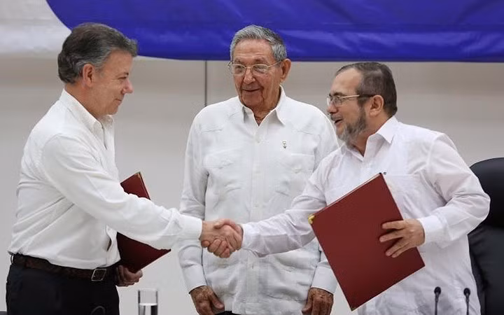 Chủ tịch Raul chứng kiến Tổng thống Colomiba Juan Manuel Santos (trái) bắt tay với thủ lĩnh lực lượng nổi dậy FARC Rodrigo Londono (phải), sau khi ký kết thỏa thuận ngừng bắn lịch sử giữa quân đội Colombia và FARC.