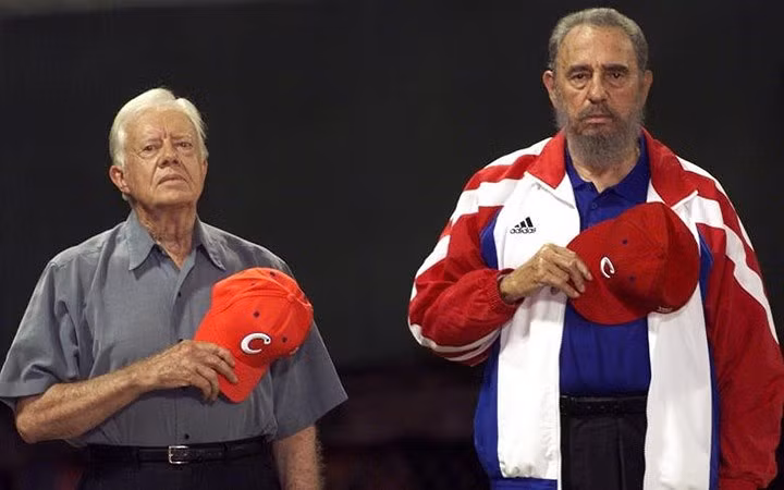 Lãnh tụ Fidel cùng cựu Tổng thống Mỹ Jimmy Carter chào cờ và hát quốc ca Cuba trước trận đấu của đội tuyển bóng rổ quốc gia Cuba. Bức ảnh chụp tại Havana ngày 24/5/2012.