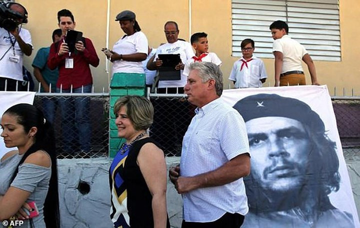 Ông Miguel Diaz-Canel (phải) cùng vợ Lis Cuesta (giữa) xếp hàng chờ đến lượt trong một cuộc bỏ phiếu. Ảnh: AFP./.