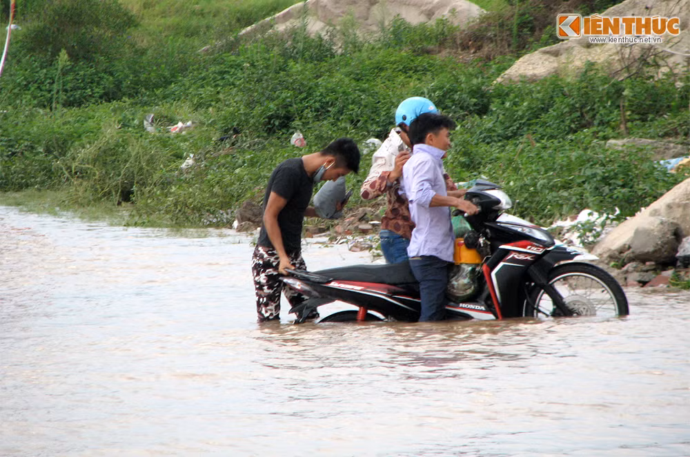 Một xe máy cố vượt qua vùng nước ngập nhưng bất thành. Lúc 16h ngày 26/5, tình hình ngập úng tại đây vẫn chưa được cải thiện.