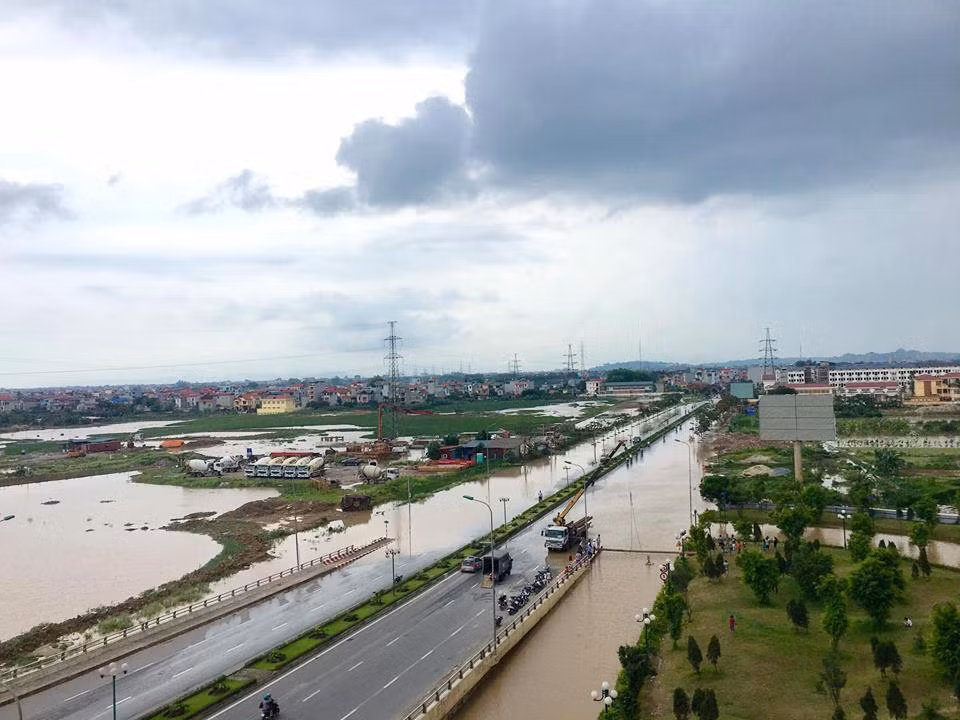 16h30, một cây cầu tạm đang được triển khai đưa người dân thoát từ tòa nhà ra khỏi khu vực nước chia cắt. (ảnh Thu Hiền)