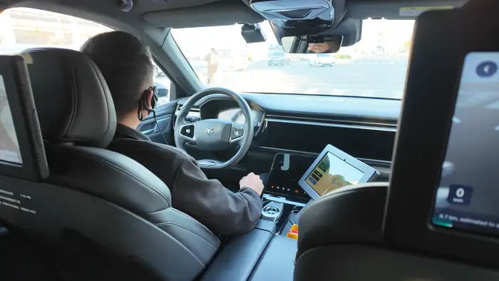 Dù được quảng bá là xe tự hành, nhưng chuyến đi của cô vẫn có một tài xế an toàn ngồi bên trong. (Ảnh: Đời sống pháp luật)