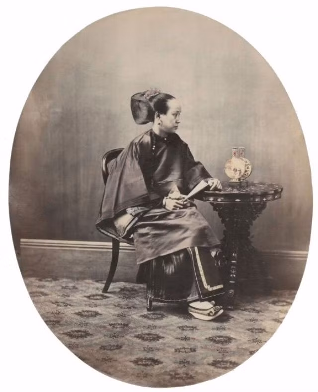 Người phụ nữ giàu có tới từ Quảng Châu ăn vận trang phục áo lụa truyền thống ngồi trên chiếc ghế kiểu phương Tây. Ảnh VT