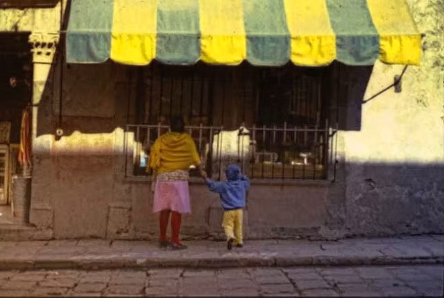 Hai mẹ con ra quán bán hàng tạp hóa nhỏ ở quê để mua đồ. Ảnh VT