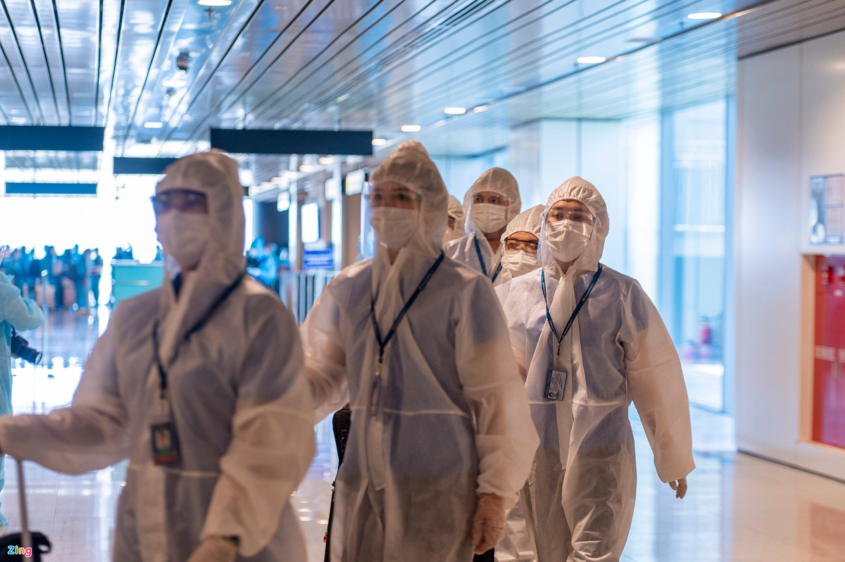 Các nhân viên phục vụ trên chuyến bay của Vietnam Airlines sau khi hoàn tất thủ tục nhập cảnh sẽ quay trở lại máy bay để bay về Hà Nội thực hiện cách ly theo quy định.