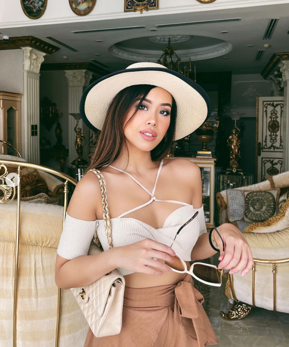 Tiên Nguyễn mặc một chiếc áo trễ vai kết hợp chân váy ngắn, đầu đội mũ, tay cầm kính, vai đeo túi hiệu. Ở nhà thôi nhưng ái nữ tỷ phú trông vẫn "chanh sả" khi quần áo chỉn chu.