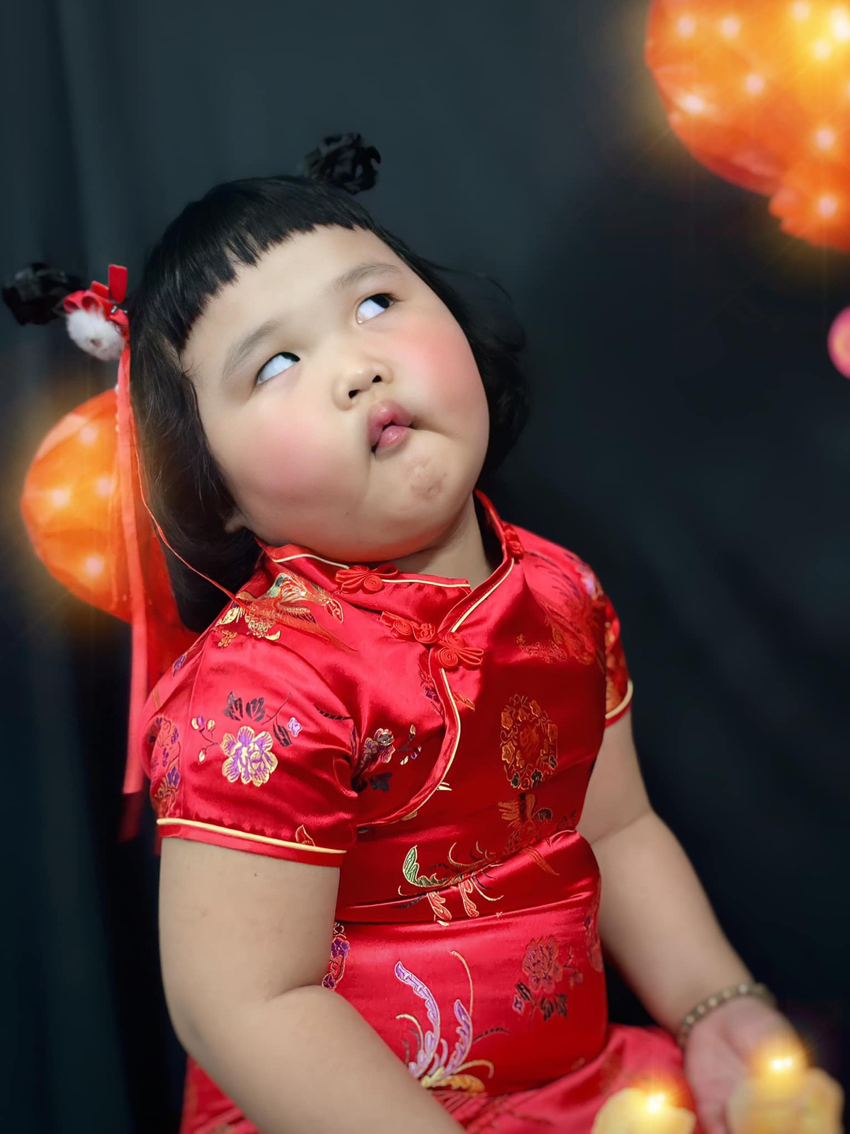 Khoác trên mình bộ đồ màu đỏ, bé gái trông vô cùng đáng yêu khi sở hữu khuôn mặt mũm mĩm, làn da trắng cùng tóc mái ngố.