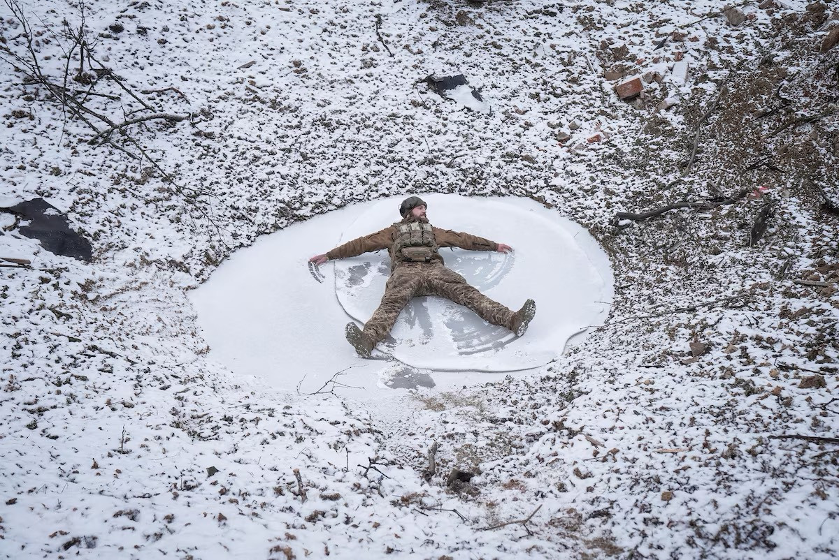 Một quân nhân Ukraine thuộc Lữ đoàn tấn công đường không số 80 nghịch tuyết trong hố bom gần thị trấn Bakhmut.