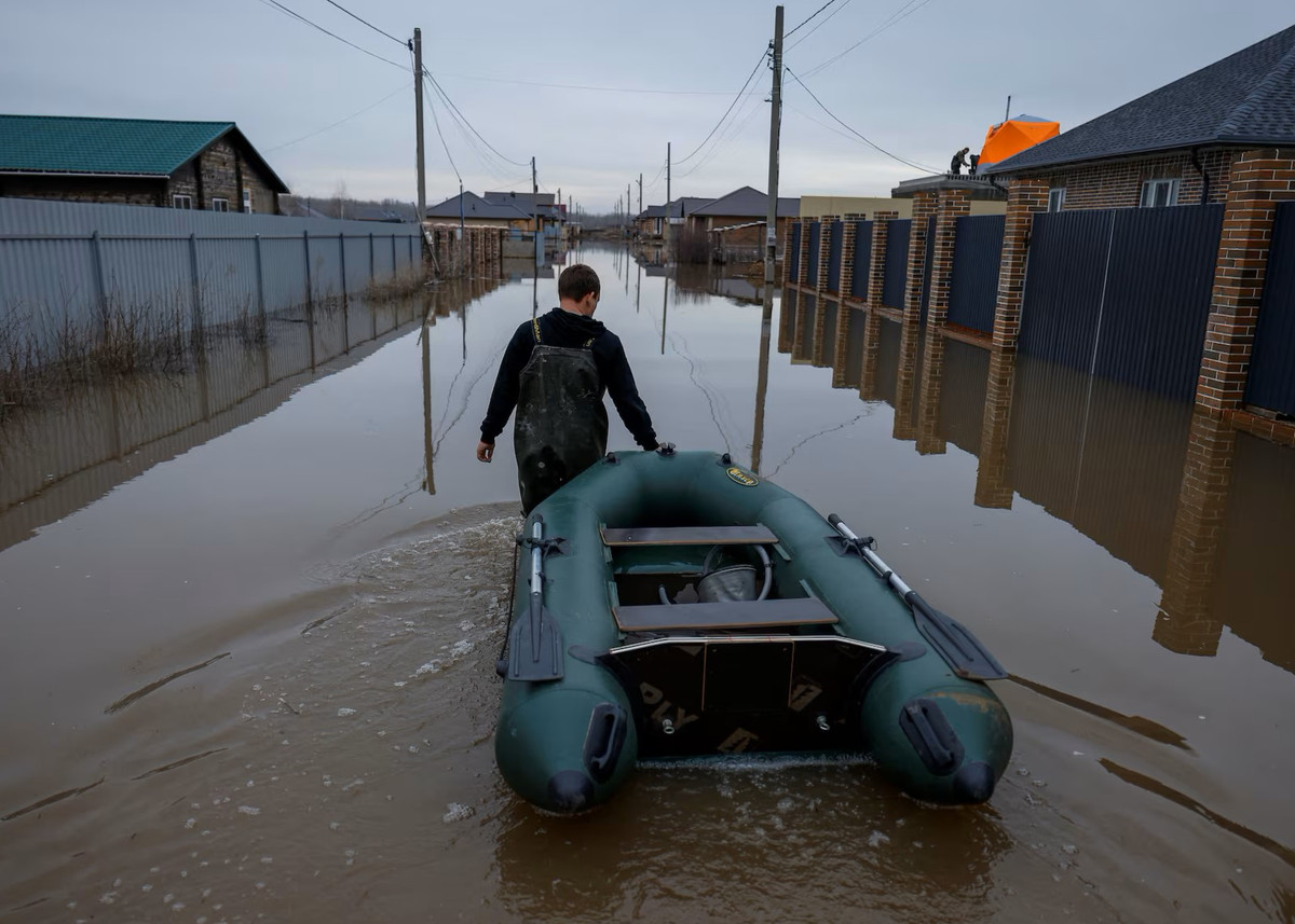 Một người đàn ông đang kéo chiếc thuyền bơm hơi dọc con phố ở khu định cư Ivanovskoye.