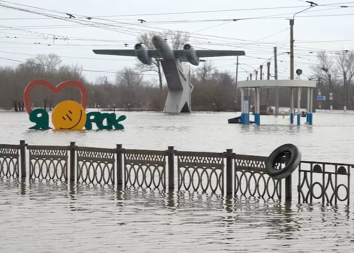 Tấm biển ghi "Tôi yêu Orsk" gần tượng đài các phi công trên con đường ngập nước lũ ở Orsk, Nga.