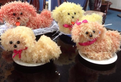 Bưởi mua về gọt vỏ, tách múi và lộn ngược phần vỏ vào trong để phần tép bưởi lộ ra bên ngoài. Dùng tăm tẽ cho các tép bưởi tơi ra rồi gắn lên khung hình đã chuẩn bị sẵn. Lần lượt gắn múi bưởi lên cho đến khi che kín phần khung. Sau đó bạn chỉ cần gắn hạt nhãn vào làm mắt và mũi cho chú chó bưởi.