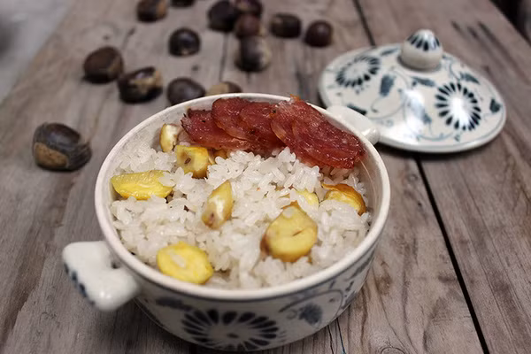 Sau khi tắt bếp, xới xôi ra đĩa, rắc lạc rang giã nhỏ và vừng lên trên. Xôi hạt dẻ cũng có thể ăn kèm nước cốt dừa, hành khô thêm đậm đà, hoặc ăn kèm ruốc, lạp xưởng cho đa dạng hương vị. Ảnh: Internet.