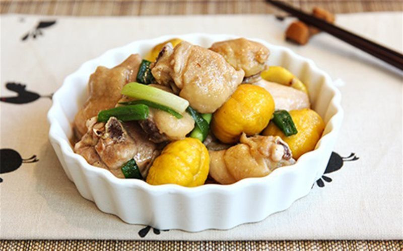 Gà hầm hạt dẻ: Gà sơ chế sạch, để ráo nước. Sau đó dùng nước tương chà xát lên bề mặt gà cho thấm màu, cắt vài lát gừng nhỏ để ướp gà. Lấy 1 chén tỏi lột sạch vỏ, phi thơm rồi vớt ra.Tiếp đến cho gà vào chiên vàng bề mặt. Gà chiên xong sẽ có màu giống như màu thịt kho tàu. Vớt gà ra để ráo dầu.