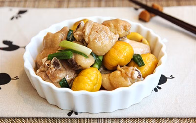 Gà hầm hạt dẻ: Gà sơ chế sạch, để ráo nước. Sau đó dùng nước tương chà xát lên bề mặt gà cho thấm màu, cắt vài lát gừng nhỏ để ướp gà. Lấy 1 chén tỏi lột sạch vỏ, phi thơm rồi vớt ra.Tiếp đến cho gà vào chiên vàng bề mặt. Gà chiên xong sẽ có màu giống như màu thịt kho tàu. Vớt gà ra để ráo dầu.