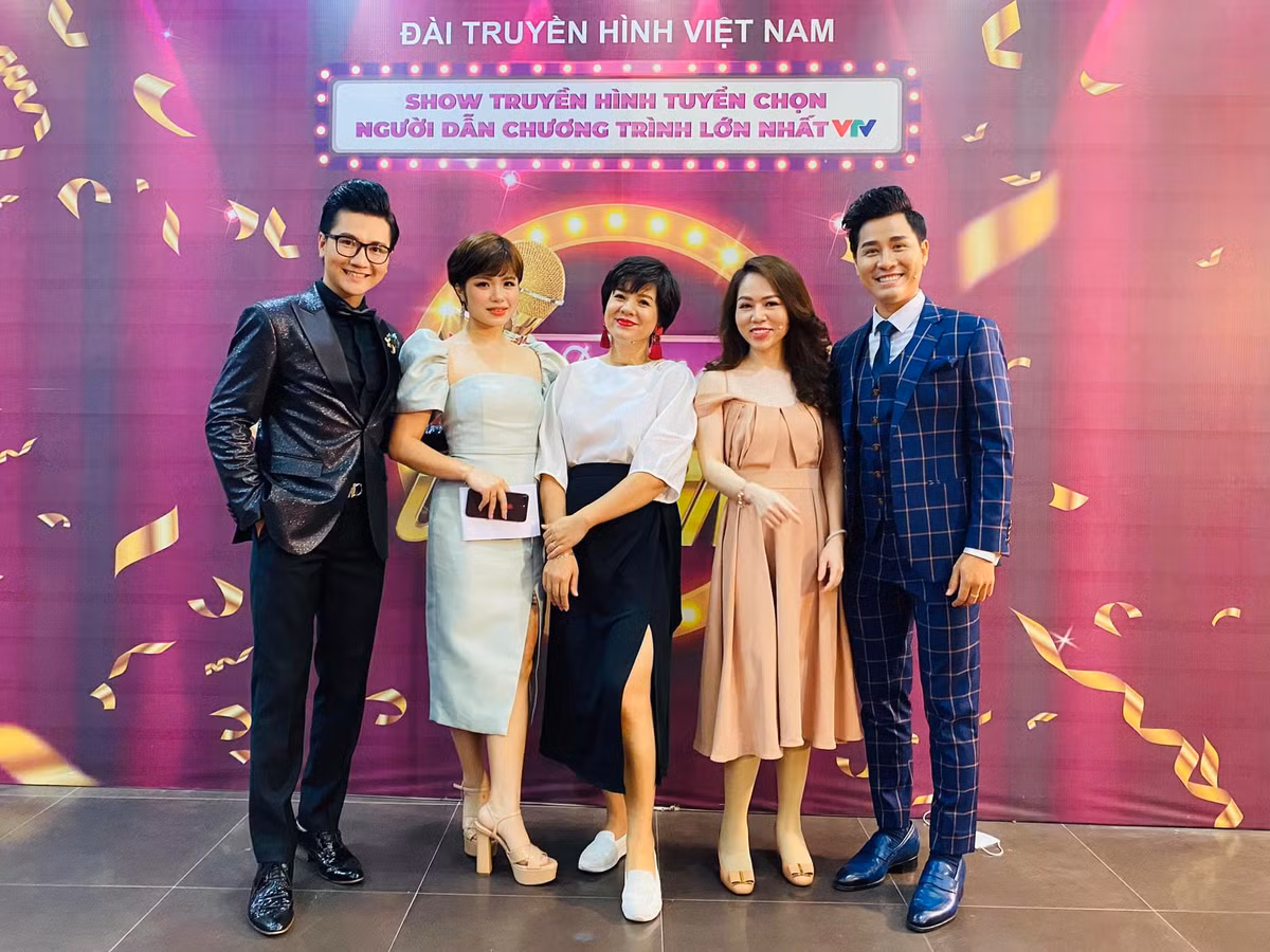 Nữ MC tài năng trẻ trung với áo sơ mi trắng phối cùng chân váy xẻ cao khoe chân dài.