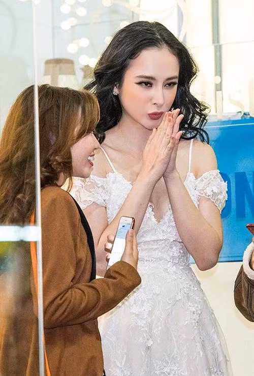 Trong khi mọi người xung quanh đều mặc áo khoác dày kín kẽ, Angela Phương Trinh vừa đứng vừa run vì chiếc váy ren mỏng manh, khoét ngực lộ vai này.